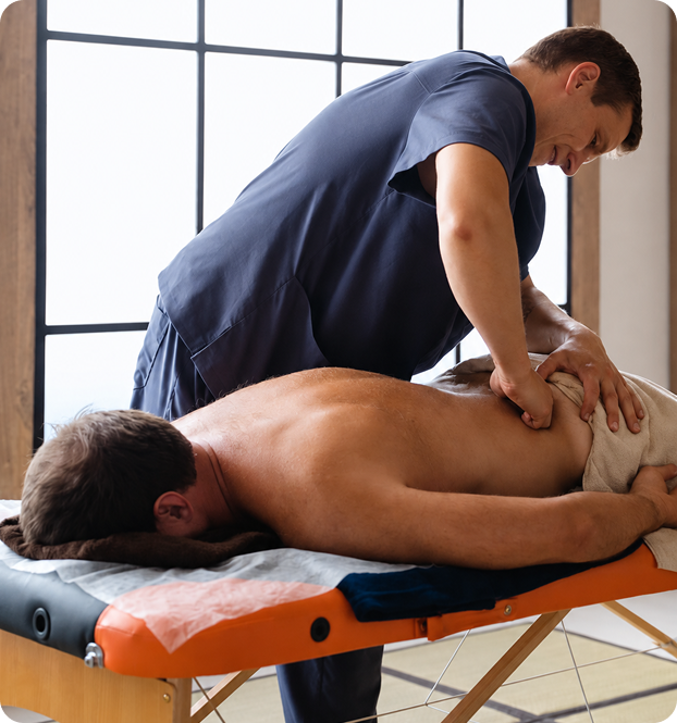 Therapist working on a man's lower back on a massage table